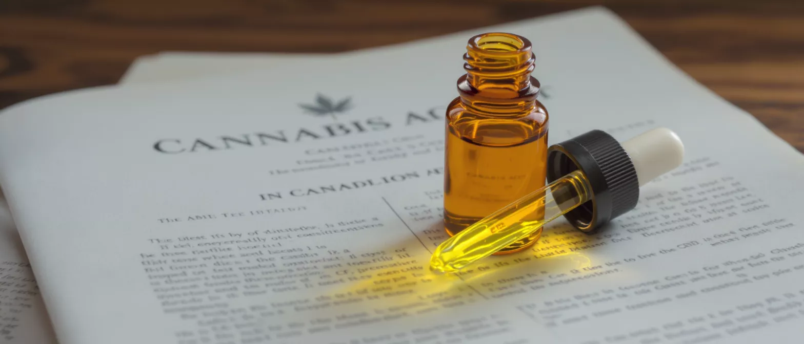 Flacon compte-gouttes ambré avec huile de cannabis sur un document juridique orné d'une feuille de cannabis.