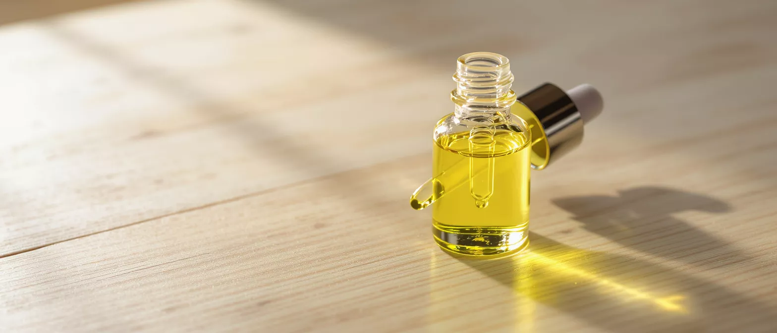 Glass dropper bottle filled with yellow oil