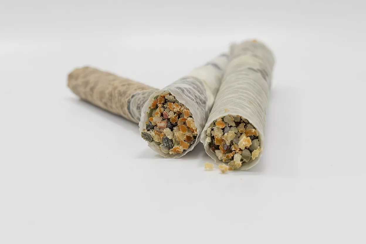 Three Seed and Nut Rolls Three rolls filled with seeds and nuts, wrapped in delicate paper, on white background.