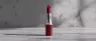 THC lipstick balm with cannabis leaf on table