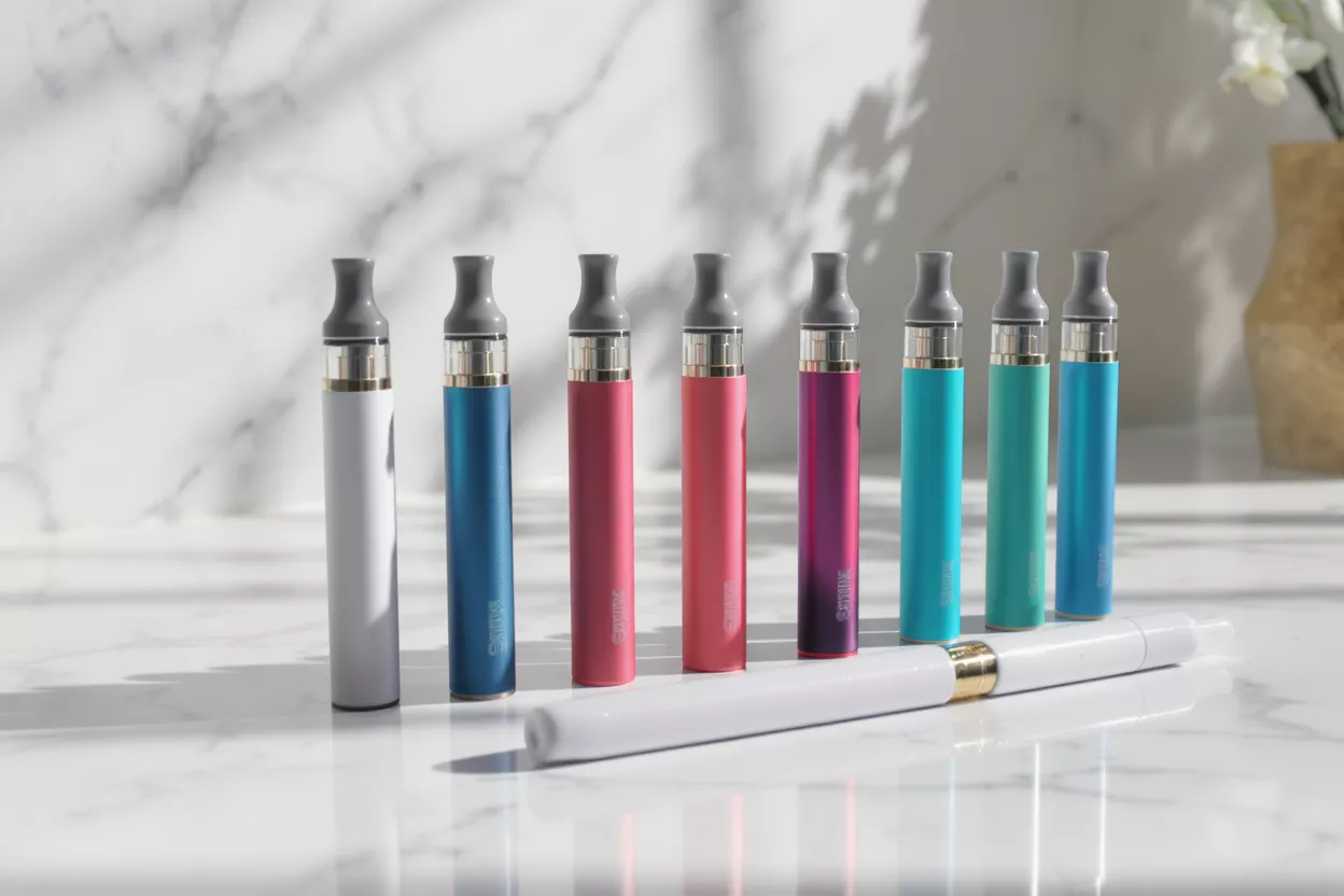 Bolígrafos Vape Coloridos Siete bolígrafos vape coloridos de pie y un bolígrafo vape blanco acostado.