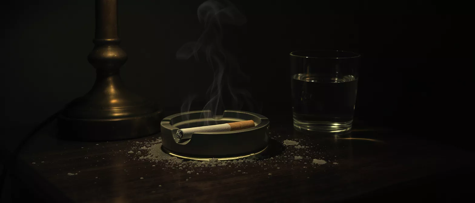 A cigarette resting in an ashtray with smoke rising
