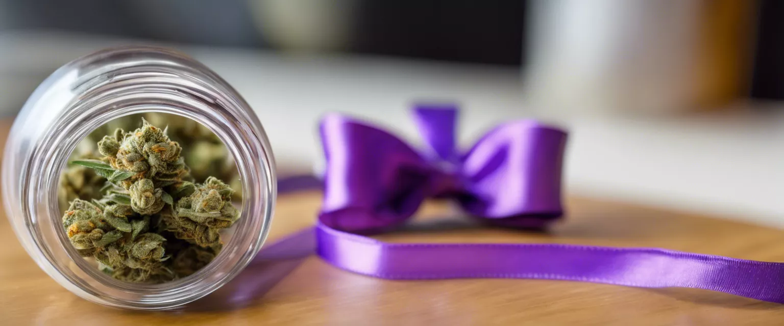 Cannabis buds in jar beside purple ribbon on polished wood surface.