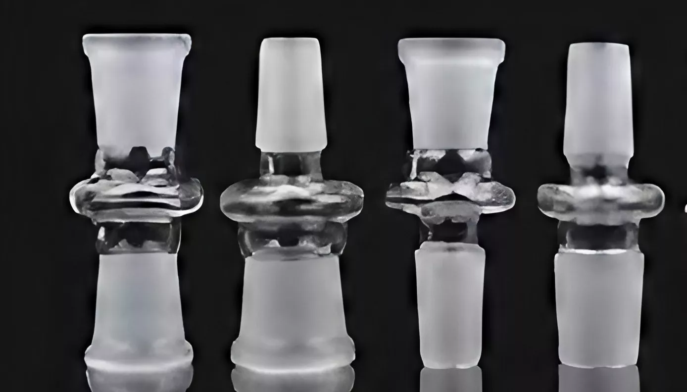 Four glass lab stoppers against black background, essential for scientific flask sealing.