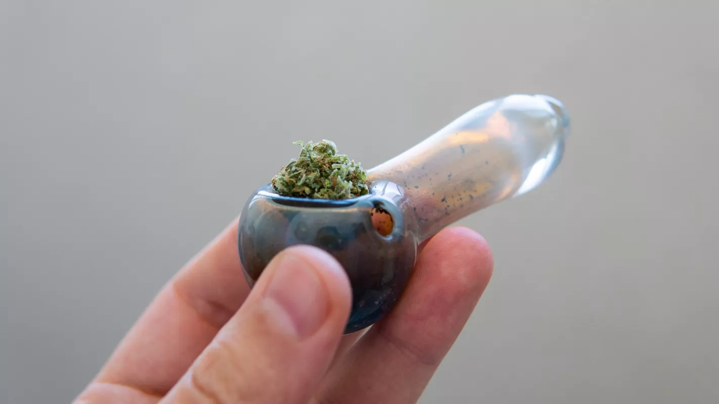 Handheld glass pipe with cannabis ready for use.