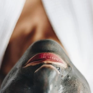 Person with a facial mask and red lipstick
