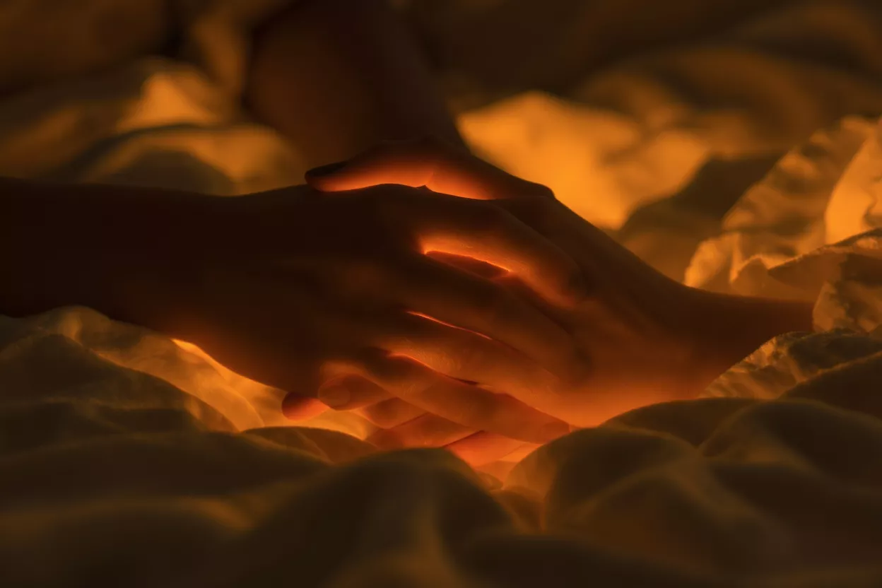 Glowing Hands in Warm Light Two hands cupped together, glowing with a warm orange light from within.