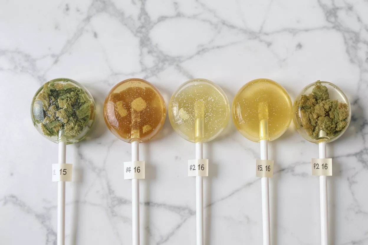 Colorful Lollipops with Unique Ingredients Five lollipops with different ingredients on a marble surface