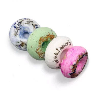 Assorted bath bombs in marble blue, herbal green, and vibrant pink for a relaxing bath.