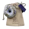 Handmade bath bomb with dried botanicals and fabric pouch.