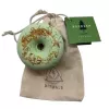 Pale green CBD bath bomb with dried flowers and drawstring bag.