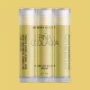 Three Piña Colada lip balm tubes with CBD, by Birch + Beauty, against yellow background.
