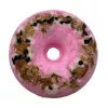 Pink donut-shaped bath bomb with dried botanical toppings.