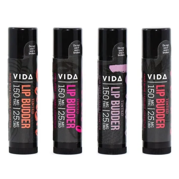 Four VIDA Lip Budder sticks with color-coded labels, indicating tinted moisturizer variety, 150mg.