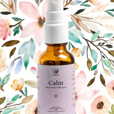 CALYX Calm Peppermint CBD Spray bottle for relaxation on a floral background.