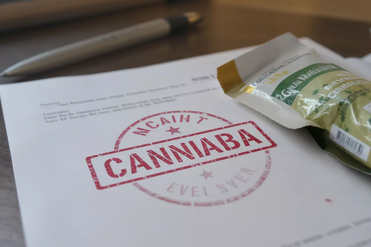 Cannabis Product with QR Code Smartphone displaying QR code next to a cannabis product box on marble.