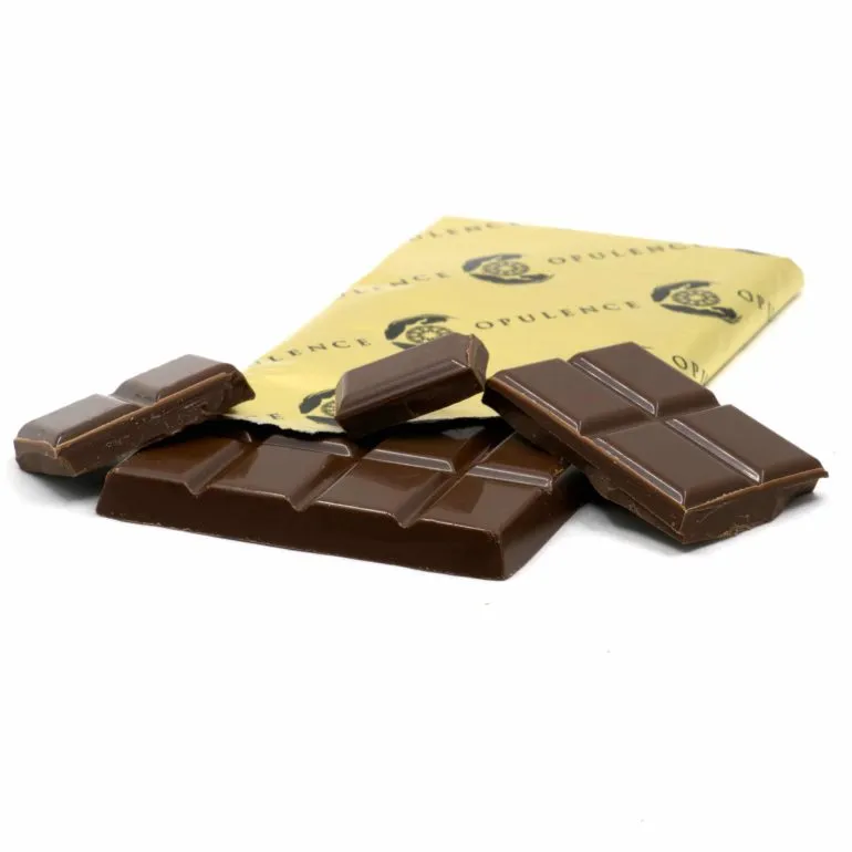 Premium dark chocolate pieces with glossy finish and vibrant yellow packaging on white background.