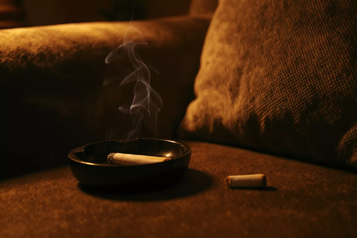 Candle burning on a couch with smoke rising