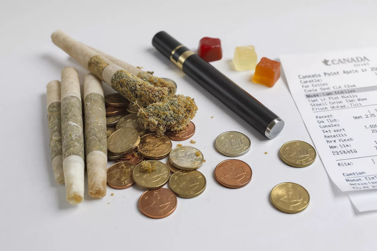 Cannabis Products and Canadian Receipt Cannabis joints, loose flower, vape pen, gummies, coins, and a Canadian receipt.