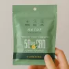 Green natural lozenges package highlighting CBD, lemon, mint flavor, and health benefits.