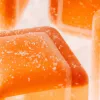 Orange translucent cubes with sugar coating, resembling jellies or gummies, highlighted in macro view.