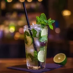 Refreshing mojito cocktail with mint, lime, and ice, in a cozy bar setting.