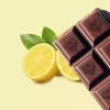 Rich chocolate bar and juicy lemon on a yellow background, showcasing balance and contrast.