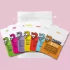 Various colored snack packages arranged beside a white drawstring bag on a pink background.