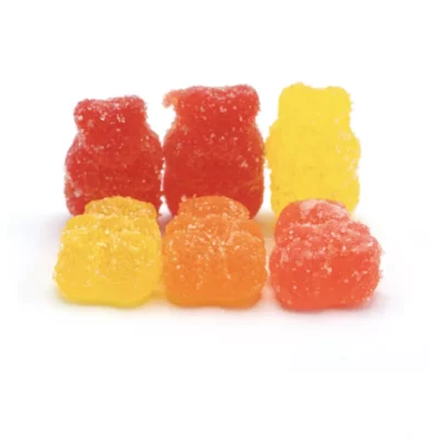 Colorful, sparkling gummy bears arranged in rows on white background, sugary vegan treats.