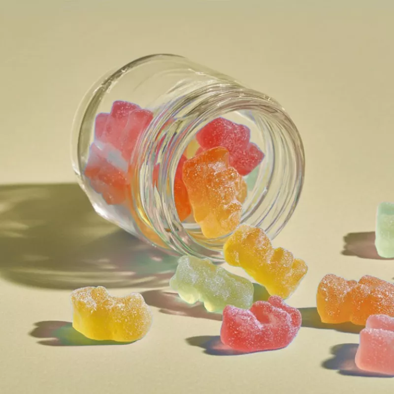 A jar spilling colorful gummy bear candies