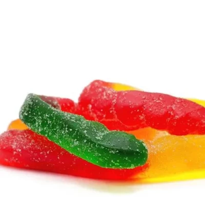 Bright green and red sugar-coated gummy worms with glossy finish, white background.