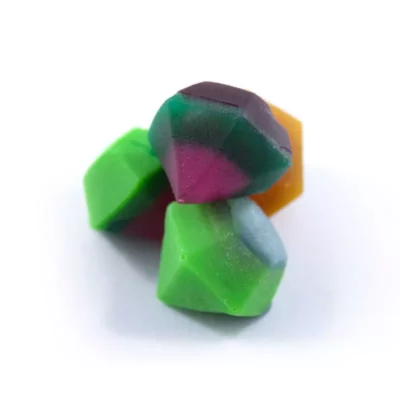 Gem-like THC gummies in assorted colors on white background.