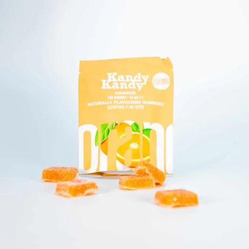 Kandy Kandy citrus gummies in orange packaging with sugar-coated candies on blue gradient.