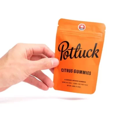 Hand holding Potluck Citrus Gummies package, Cannabis Infused, 10mg THC total.