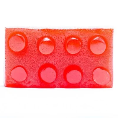 Red sugar-free THC gummy in LEGO brick shape against white background.