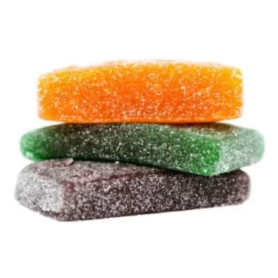 Colorful sugar-coated candies in orange, green, and purple with a sparkling, crunchy texture.