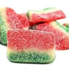 Colorful MOTA Sativa THC-infused sugar-coated watermelon gummy slices, resembling fruit colors.
