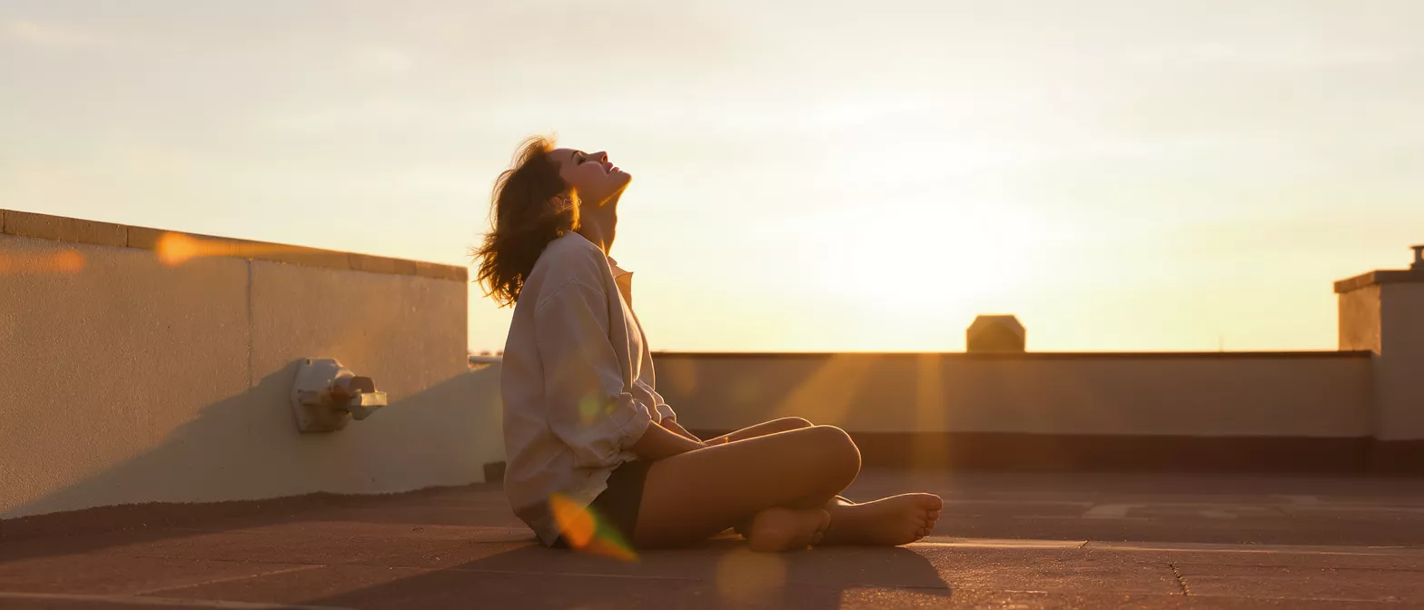 Woman meditating on a rooftop during sunset