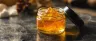 Golden live rosin concentrate in a small glass jar
