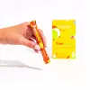 Hand holding YumBiotic probiotic supplement packet for digestive health, vibrant design.