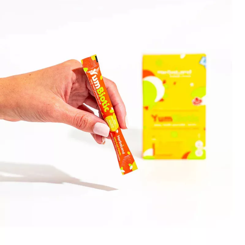 Vibrant YumBiotic Probiotic Packet for Digestive Health Hand holding YumBiotic probiotic supplement packet for digestive health, vibrant design.