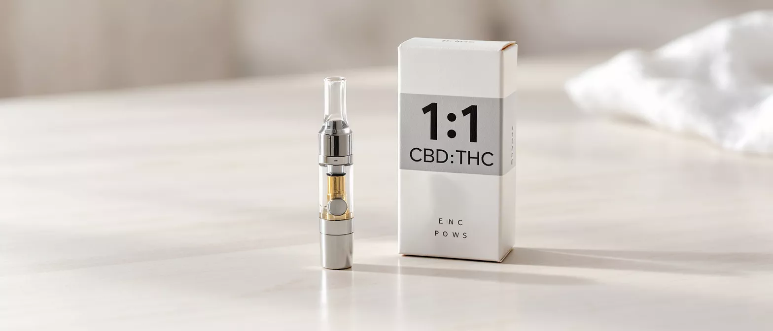 A sleek silver vape pen next to a white box labeled "1:1 CBD:THC."