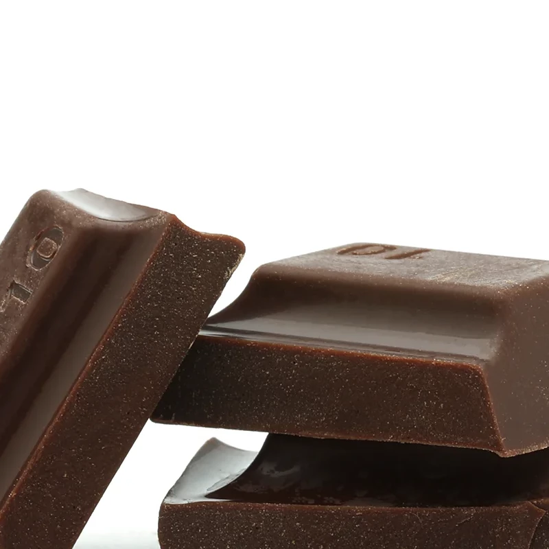 Three glossy dark chocolate bars stacked with rich texture and natural imperfections.