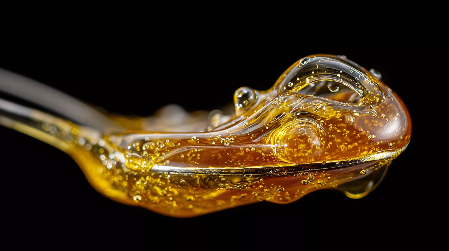 Close-up of golden honey or syrup on a spoon with glossy texture and bubbles.