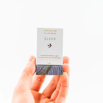Hand holding Cannalier CBD Sleep Aid with calming design for muscle relaxation and better sleep.