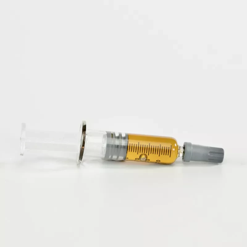 Pre-filled syringe with CBD oil, capped needle, on white background.
