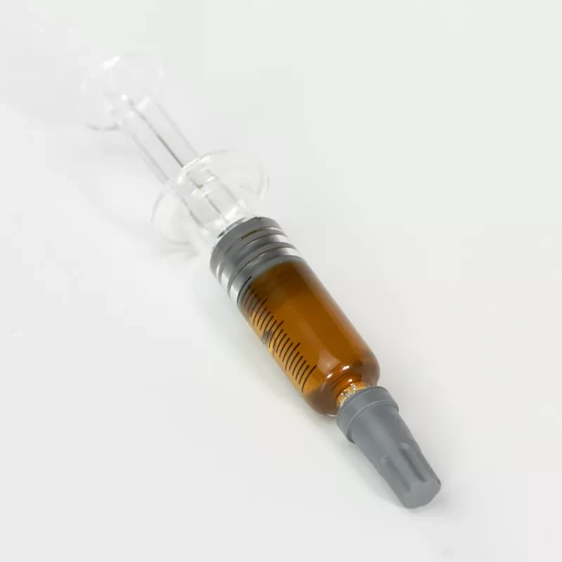 Syringe with THC honey oil against white background, capped needle visible.
