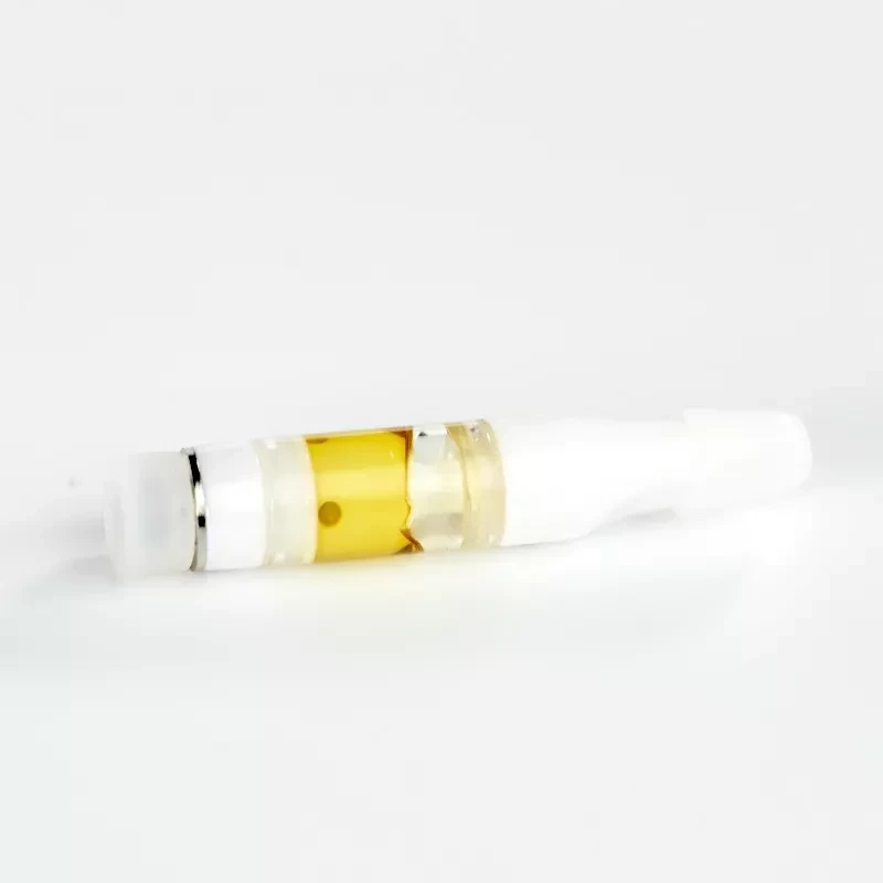 Vape cartridge with golden cannabis oil close-up on white background.