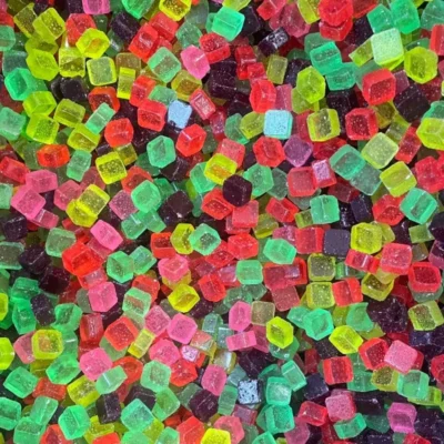 Assorted colorful gummy candies coated in sugar closeup.