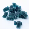 Close-up of blue gummy bear candies on white background.